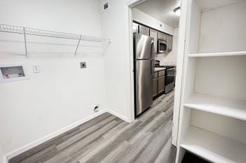 An empty kitchen with a stainless steel refrigerator